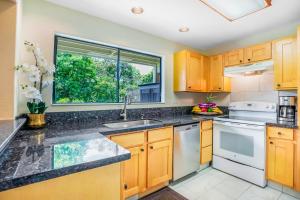 a kitchen with wooden cabinets and a window at Hale Moi #103A in Princeville