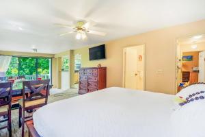 a bedroom with a white bed and a ceiling fan at Hale Moi #103A in Princeville