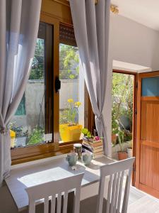 a white table and chairs in a room with a window at Sunny guest house in Vlorë