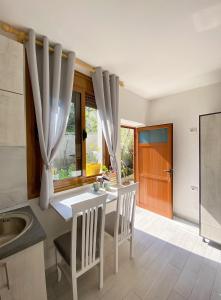 a kitchen with a table and chairs and a sink at Sunny guest house in Vlorë