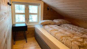 a bed in a room with a window and a table at Penthouse by the ski lift, 4 bedrooms, 2 living rooms in Stranda