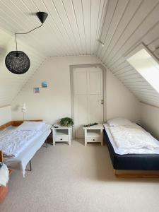 a bedroom with two beds and a ceiling at Lilleledgaard in Ringkøbing