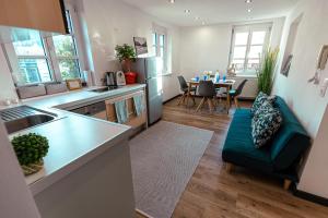 a kitchen and living room with a couch and a table at #lowcosthighcomfort in Leoben