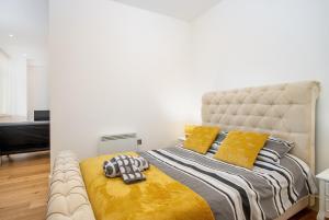 een slaapkamer met een groot bed met gele kussens bij 602 Luxury Apartment near Luton Town and Station in Luton