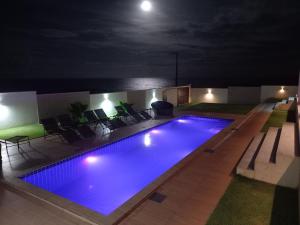 a swimming pool at night with the moon in the background at Vilamar in Tibau do Sul