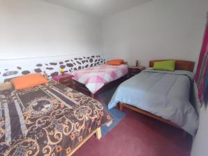 Habitación con 2 camas en una habitación en Wayra Wasi, en Coporaque