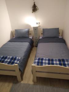 two beds in a bedroom with blue and white sheets at Apartment Ammonite in Premantura