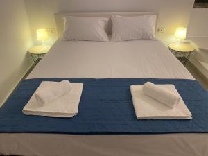 a bed with two towels sitting on top of it at BIANCO BLUE in Tinos