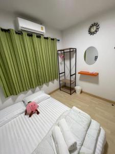 um quarto com um porco de peluche cor-de-rosa numa cama em M Villa @ Impact Muangthongthani em Ban Bang Phang