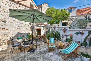 une terrasse avec une table, des chaises et un parasol dans l'établissement Rooms Tomic, à Split