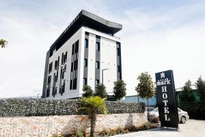 een wit gebouw met een bord ervoor bij Mark Hotel Tirana in Tirana