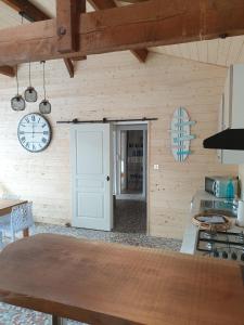 a kitchen with a table and a clock on the wall at Belle Océane in Lège +18 photos
