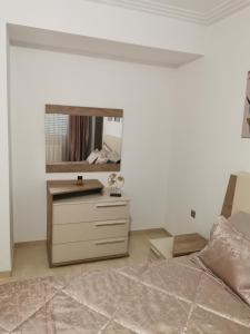 Palm Lake Resort (FOLLA) Sousse-Monastir في المنستير: غرفة نوم مع سرير ومرآة على الحائط