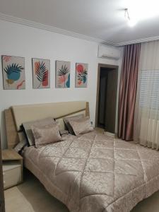 Palm Lake Resort (FOLLA) Sousse-Monastir في المنستير: غرفة نوم بسرير كبير ولوحات على الحائط