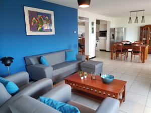 uma sala de estar com um sofá e uma mesa em Fabulous ocean view near beaches restaurants in a secured apartment resort em Willemstad