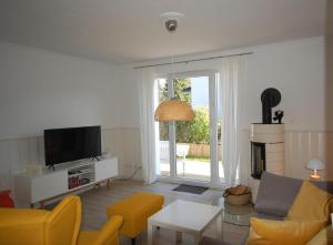 sala de estar con sofá y TV en Kiepenberg-9a-Scharbeutz-Kie-009, en Scharbeutz