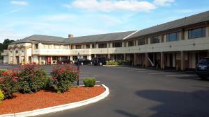 a large building with cars parked in a parking lot at Rodeway Inn Bristol near Sesame Place in Levittown