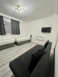 a living room with a couch and a tv at Comfortable - Cosy - Budget Studios in City Center in London