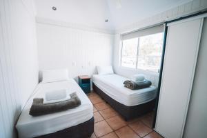 a bedroom with a bed and a window at BIG4 Breeze Holiday Parks - Rainbow Beach in Rainbow Beach