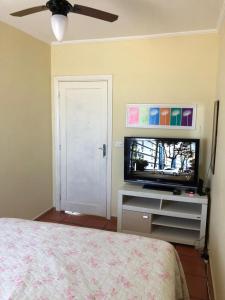 1 dormitorio con 1 cama y TV de pantalla plana en Prainha Pousada - Bar e Restaurante, en Itanhaém