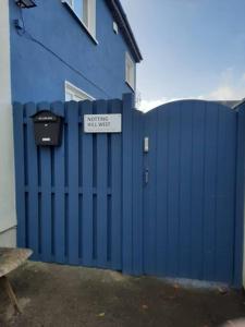 Uma cerca azul com um sinal que lê esta casa é inútil. em Notting Hill West in the heart of Westport Town em Westport