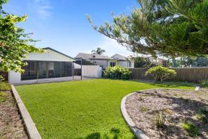 a house with a yard with a grass yard at Shelly Beach Holiday Home in Shelly Beach