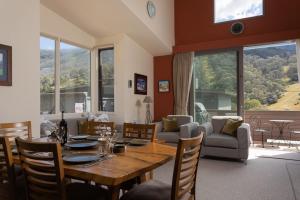 a dining room with a table and a living room at Squatters Run 12a in Thredbo