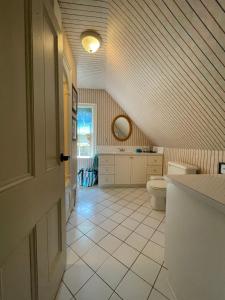 an attic bathroom with a toilet and a sink at Avonlea Forest Hill Cottages in New Glasgow