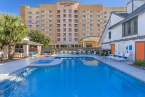 a large swimming pool in front of a hotel at Studio w Handicap access - Walk to Texas Medical Center, NRG, Rice University, Parks, Zoo in Houston