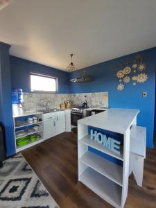 a kitchen with blue walls and a white counter top at Casa Pascuala in Dalcahue