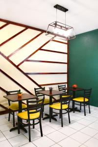 a dining room with tables and yellow chairs at Hotel San Jose, Matagalpa. in Matagalpa