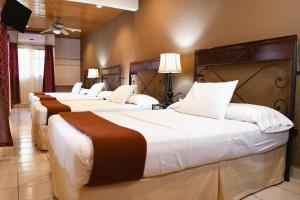 a row of three beds in a hotel room at Hotel San Jose, Matagalpa. in Matagalpa