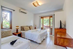 1 dormitorio con 2 camas y TV. en Barcaça Pousada en Itacaré