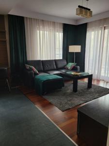 a living room with a couch and a coffee table at Apartament LUNA Francuska Park in Katowice