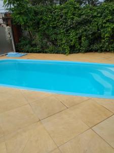 a large blue swimming pool on a tile floor at Casa com piscina Temporada Foz do Iguaçu in Foz do Iguaçu