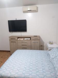 a bedroom with a bed and a flat screen tv at Casa com piscina Temporada Foz do Iguaçu in Foz do Iguaçu