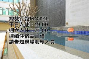 a sign for a hotel with a reflection of a pool at 總裁行館Motel in Guishan