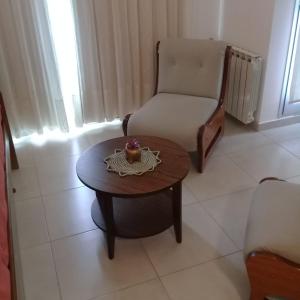 a living room with a chair and a coffee table and a chair at Veluvi in Puerto Madryn