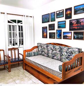uma sala de estar com um sofá e quadros na parede em Apartamento Cabo Frio 2 QUARTOS 250 METROS DA RODOVIÁRIA em Cabo Frio