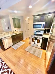 a large kitchen with wooden floors and stainless steel appliances at COZY DOWNTOWN APARTMENT-Naval Academy Vicinity in Annapolis