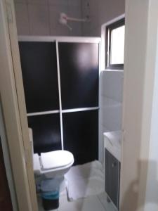 a bathroom with a white toilet and a sink at Casa com piscina Temporada Foz do Iguaçu in Foz do Iguaçu