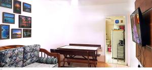uma sala de estar com uma mesa e um sofá em Apartamento Cabo Frio 2 QUARTOS 250 METROS DA RODOVIÁRIA em Cabo Frio