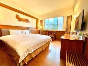 a bedroom with a large bed and a large window at Ginkgo Hotel in Lugu Lake