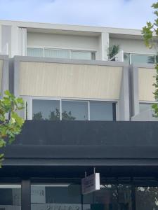 a large white building with a black roof at Designer Luxury for 2 in Mornington