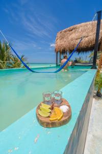 un piatto di frutta e bicchieri sul bordo di una piscina di Hotel Villas Tiburon Adults Only a Isola Holbox
