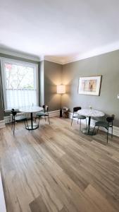 an empty living room with two tables and a window at The Century House Bed and Breakfast Ottawa in Ottawa