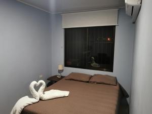1 dormitorio con 1 cama con cisnes hechos de toallas en Apartamento con dos habitaciones, en San Isidro