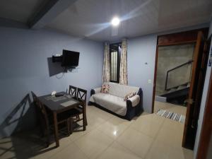 sala de estar con sofá, silla y mesa en Apartamento con dos habitaciones, en San Isidro