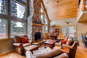 a living room with couches and a stone fireplace at Immaculate & Private Mountain Home with Hot Tub - Sugar Pine Lodge in Fairplay