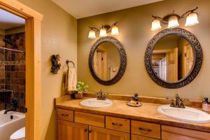 a bathroom with two sinks and two mirrors at Immaculate & Private Mountain Home with Hot Tub - Sugar Pine Lodge in Fairplay +18 photos